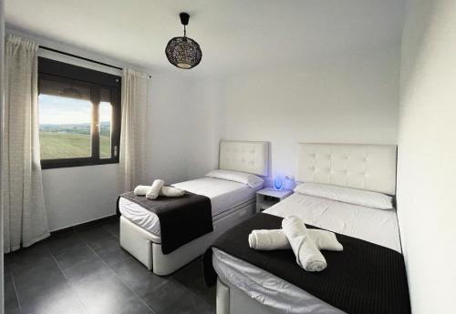 - une chambre avec 2 lits et une fenêtre dans l'établissement Atico la pace dei sensi, à Conil de la Frontera
