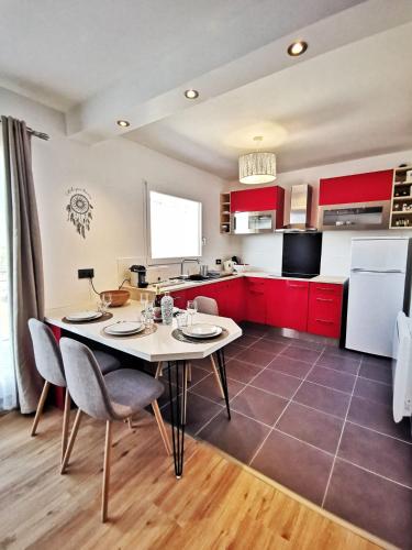 une cuisine avec des armoires rouges et une table et des chaises dans l'établissement Le 79 Reflet de la Marne, à Noisy-le-Grand