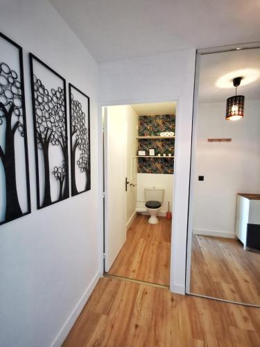 - un couloir avec des toilettes et un miroir dans l'établissement Le 79 Reflet de la Marne, à Noisy-le-Grand