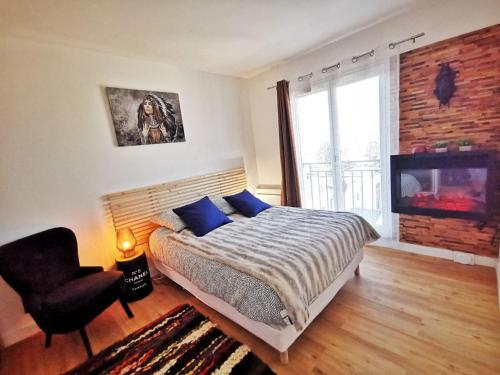 a bedroom with a bed and a chair and a television at Le 79 Reflet de la Marne in Noisy-le-Grand