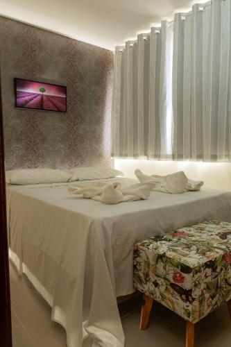 a bedroom with a bed with white sheets and a window at Pousada Elo Inn in Recife