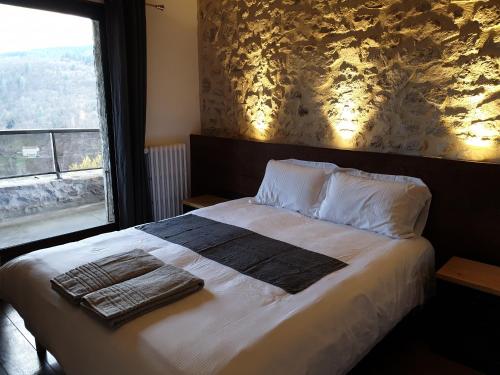 a bedroom with a large bed with a window at Là-Haut "Maison d'hôtes" in Antraigues