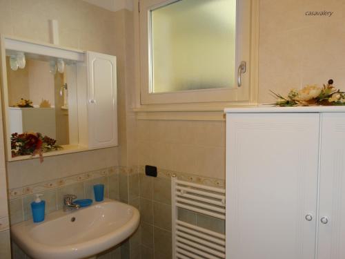 een badkamer met een wastafel en een spiegel bij Casavalery Appartamento monolocale con vista lago in Bellagio
