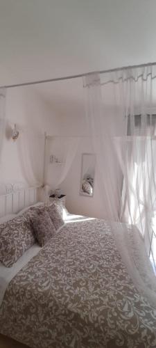 a bedroom with a bed with a canopy and a window at Appartamento Onda Marina in Polignano a Mare