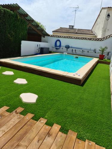 a pool with a lawn chair and a tennis ball in it at Hotel Les Vieux Acacias in Queyrac