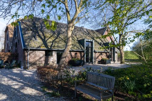a bench sitting in front of a house at Het Rentmeestershuis in Eck en Wiel