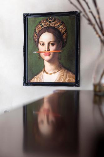 a painting of a woman with a cigarette in her mouth at Het Rentmeestershuis in Eck en Wiel