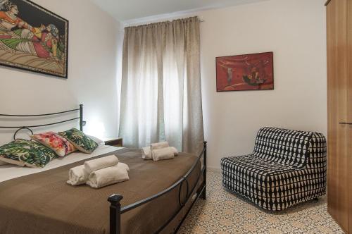 ein Schlafzimmer mit einem Bett und einem Stuhl in der Unterkunft Casa Colombo in Sperlonga