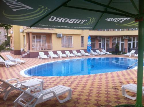 a swimming pool with lounge chairs and an umbrella at Beatris Family House in Sunny Beach
