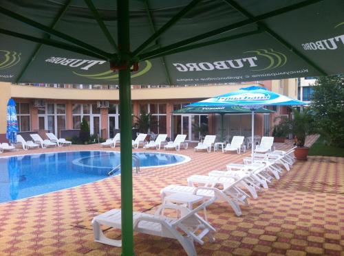 a group of chairs and umbrellas next to a pool at Beatris Family House in Sunny Beach