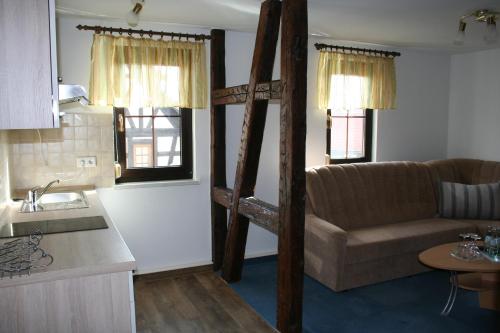 a living room with a couch and a kitchen at Gasthaus & Hotel Zur Linde in Hermsdorf