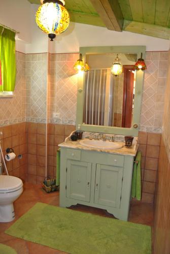 a bathroom with a sink and a mirror and a toilet at Fondaco Parrino Mare in Letojanni