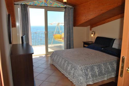 a bedroom with a bed and a view of the ocean at Fondaco Parrino Mare in Letojanni