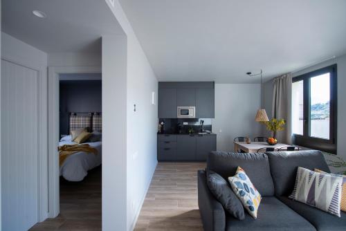 uma sala de estar com um sofá e um quarto em Apartaments Agulles de Montserrat em Monistrol