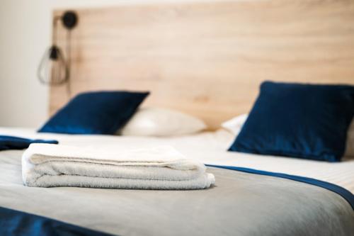 una pila de toallas en una cama con almohadas azules en Gold Hotel, en Złotoryja
