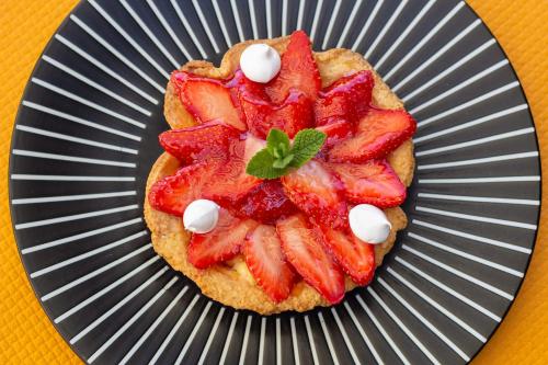 a dessert with strawberries and whipped cream on a plate at CIT'HOTEL Le Commerce in Saujon