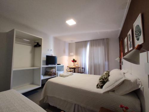 a hotel room with two beds and a television at Terrazzo Suites in Capitólio
