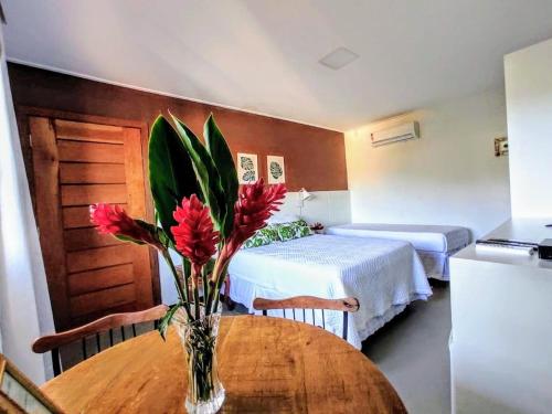 a room with two beds and a table with flowers on it at Terrazzo Suites in Capitólio