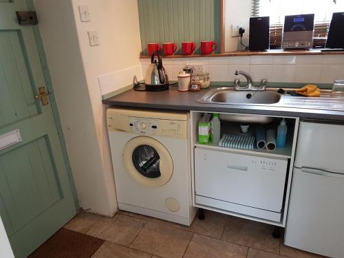 a kitchen with a washing machine and a sink at Cottage - Sleeps 4 - Pets Ok - Garden - Parking in Carnforth