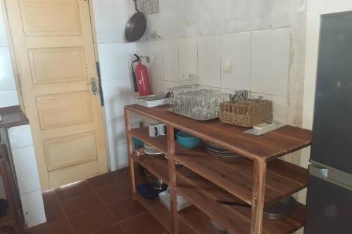 a kitchen with a wooden table and a refrigerator at Casa Alegria Tofo Beach in Inhambane