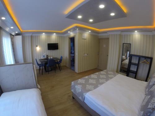 a bedroom with two beds and a dining room with a table at Meydan Suites in Istanbul