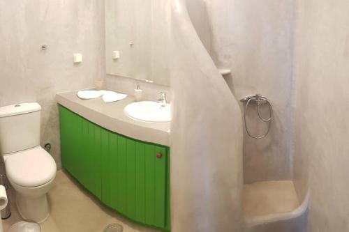 a bathroom with a green sink and a toilet at Kostos House green in Kóstos