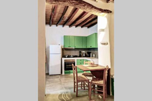 a kitchen with green cabinets and a table and chairs at Kostos House green in Kóstos
