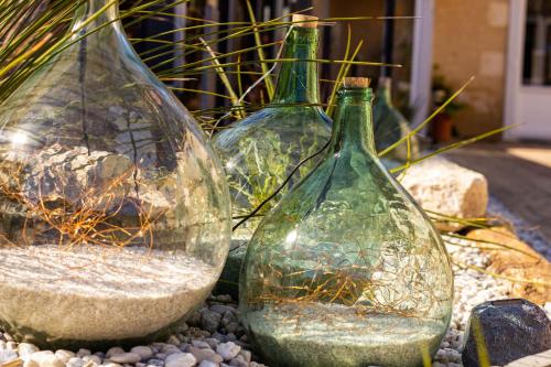 three glass vases sitting on a pile of rocks at CIT'HOTEL Le Commerce in Saujon