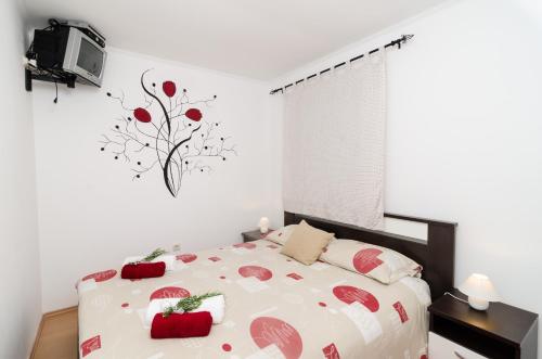 Un dormitorio con una cama con manzanas rojas. en Apartment Giovani, en Slano