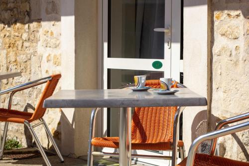 a table and chairs sitting on a patio at CIT'HOTEL Le Commerce in Saujon