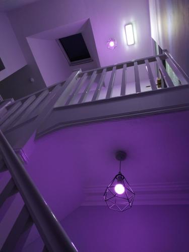 a purple room with a staircase with a light fixture at The Castleton in Blackpool