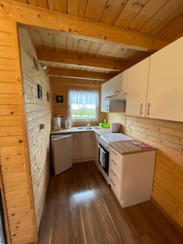 eine Küche mit Holzwänden und Holzböden in der Unterkunft Domek letniskowy in Świnoujście