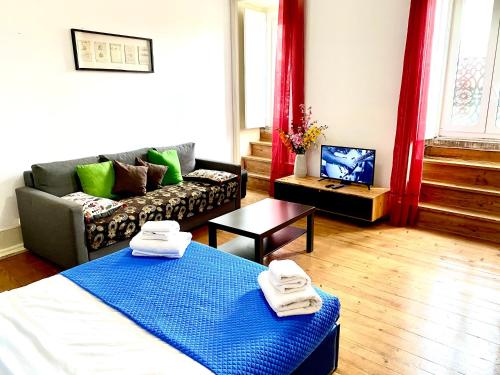 ein Wohnzimmer mit einem Bett und einem Sofa in der Unterkunft Chiado Central Guest House Lisbon Room Classic with shared bathroom in Lissabon