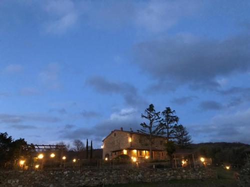 a house lit up at night with lights at Podere Le Volte Country House La Mita in Civitella in Val di Chiana