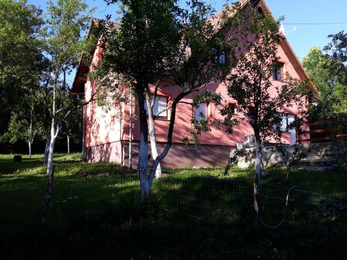 una casa rosa con árboles delante de ella en Biljevina, en Saborsko