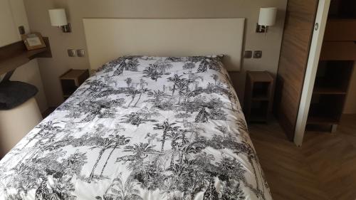 迪纳尔Côte d'Émeraude Mobilhome的一间卧室配有一张带黑白毯子的床