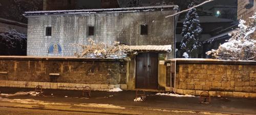 ein Backsteingebäude mit einer Tür im Schnee in der Unterkunft Baščaršija Sight in Sarajevo