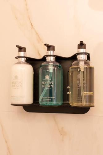 three bottles of soap on a shelf in a bathroom at Het Rentmeestershuis in Eck en Wiel