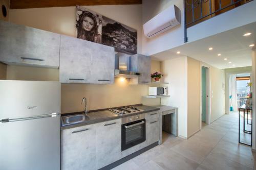 a kitchen with a sink and a stove top oven at Donna Sofi Holiday House in Agerola