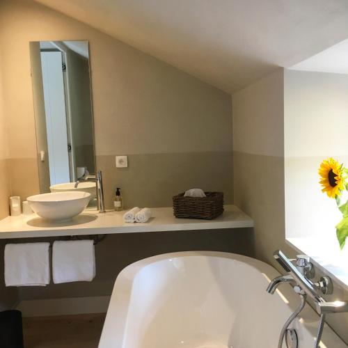a bathroom with a tub and a sink and a mirror at La Gotale - Maison d' Amis in Manhay