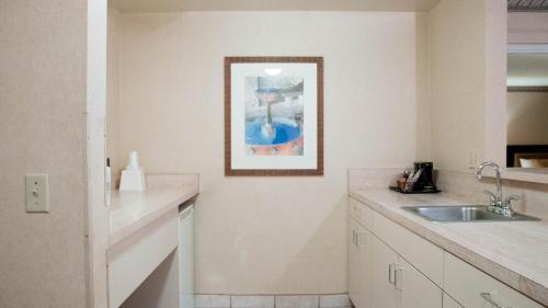 安納海姆的住宿－Studio 6 Anaheim Hills CA，厨房配有水槽,墙上挂着一幅画