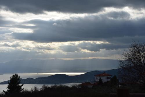 a cloudy sky with a view of a body of water at Petrichor houses in Portariá