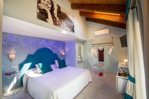 a bedroom with a white bed and a blue wall at Donna Sofi Holiday House in Agerola