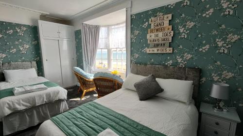 a bedroom with two beds and a window at Lichfield House in Weymouth