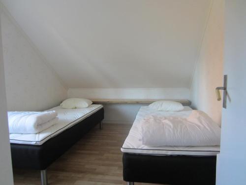 two beds in a room with white sheets and pillows at TORPET (Villa Solsidan), Hälsingland, Sweden in Arbrå
