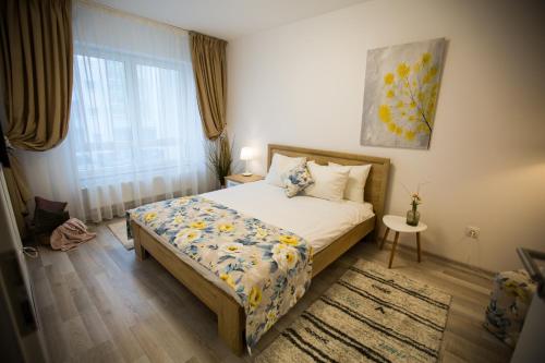 a bedroom with a bed and a window at RentForComfort Apartment Ella in Braşov