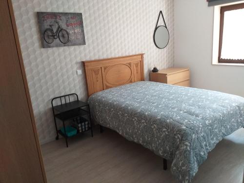 ポボア・デ・バルジンにあるEstrela de Aver o Marのベッドルーム1室(ベッド1台付)が備わります。壁に自転車の写真が飾られています。