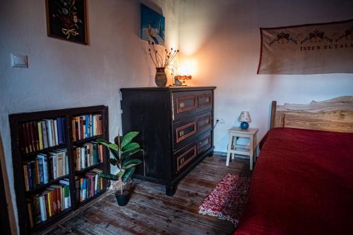 a bedroom with a bed and a book shelf with books at Main Road Seven Vendégház in Füzérradvány