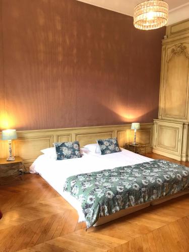 a bedroom with a large bed and two lamps at Le domaine de barbizon in Saint-Martin-en-Bière