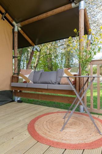 a couch sitting in a porch with a table at Het Rentmeestershuis in Eck en Wiel